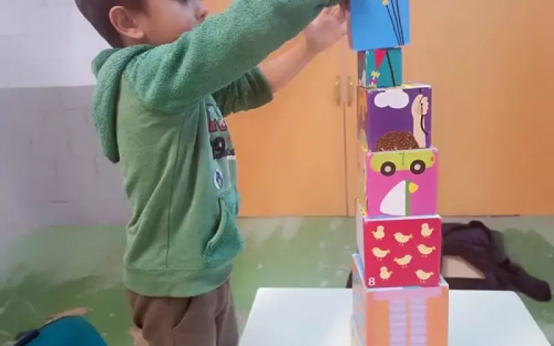 Niño jugando a apilar cajas