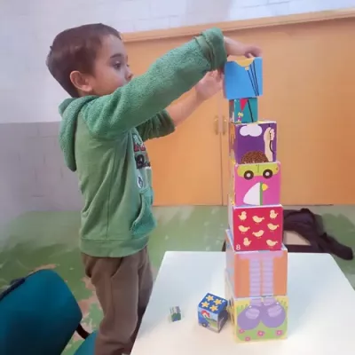 Nen jugant a apilar caixes